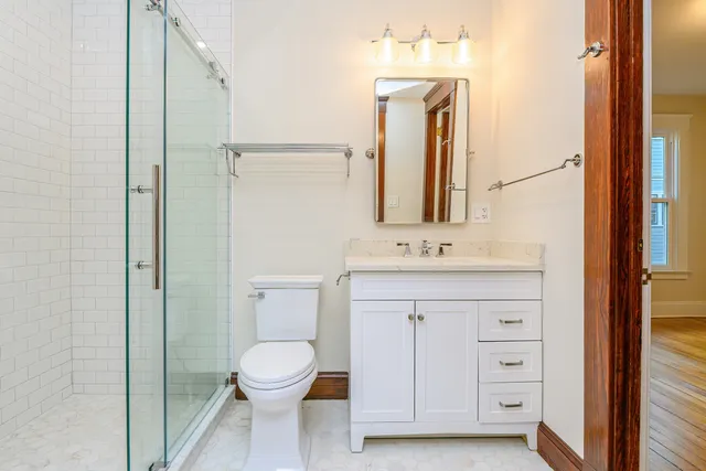 a bathroom with a sink a toilet and a mirror