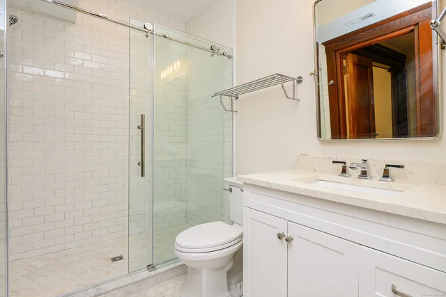 a bathroom with a sink a toilet and shower