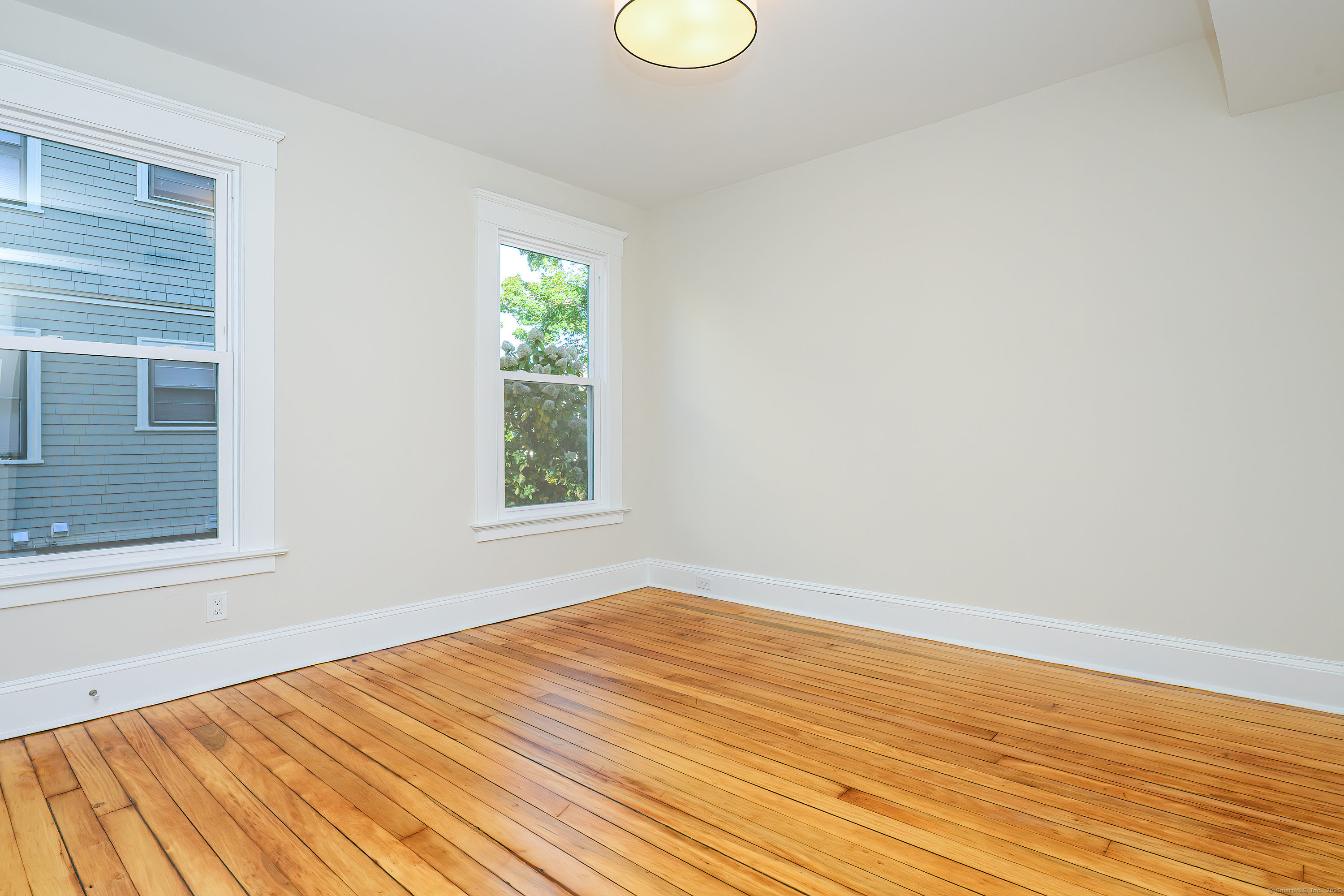 27 Hubinger Street, Unit 1 New Haven, CT 06511 - Photo 29 of 36 a view of an empty room with wooden floor and a window