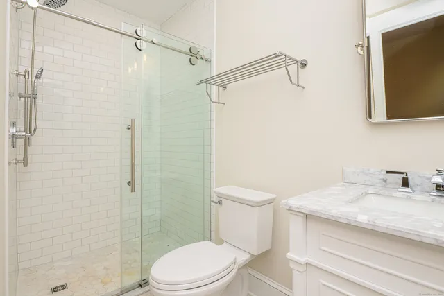 a bathroom with a granite countertop sink toilet and shower