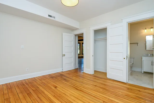 a view of empty room with wooden floor