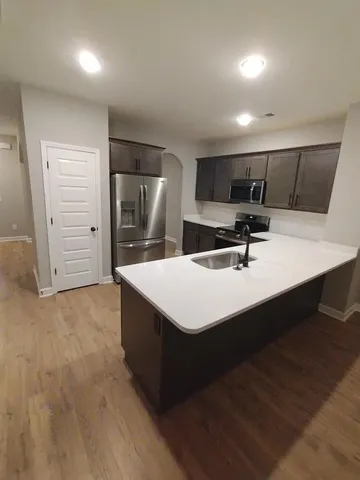 a kitchen with kitchen island a sink stainless steel appliances and cabinets