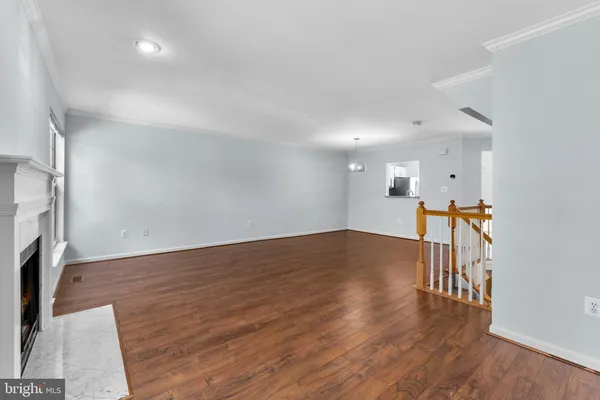 a big room with wooden floor fireplace and windows