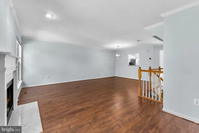 a big room with wooden floor fireplace and windows