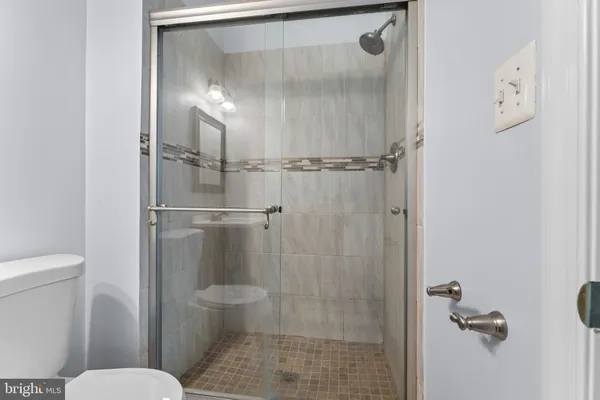 a bathroom with a granite countertop toilet and a shower