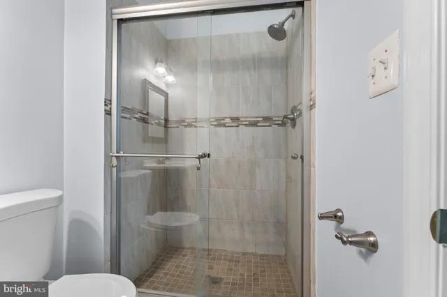 a bathroom with a granite countertop toilet and a shower