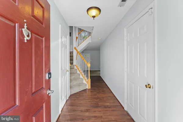 a view of a hallway with wooden floor and staircase