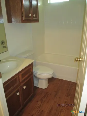 a bathroom with a granite countertop toilet and a sink