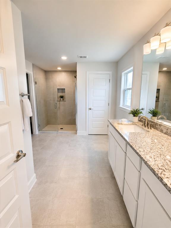 5892 Southwest 82nd Lane Ocala, FL 34476 - Photo 10 of 24 a large bathroom with a granite countertop sink a toilet a mirror and shower