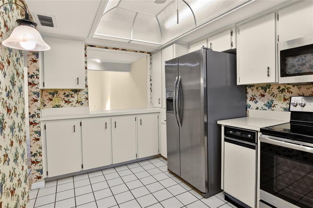 2025 Sylvester Road, Unit H3 Lakeland, FL 33803 - Photo 18 of 49 a kitchen with stainless steel appliances a stove a refrigerator and cabinets