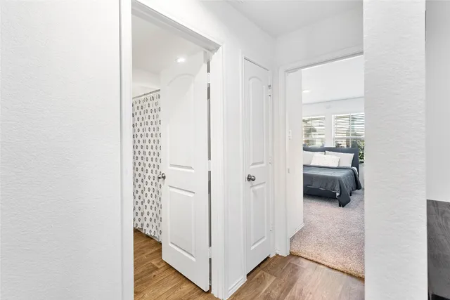 a view of a hallway with bedroom and wooden floor