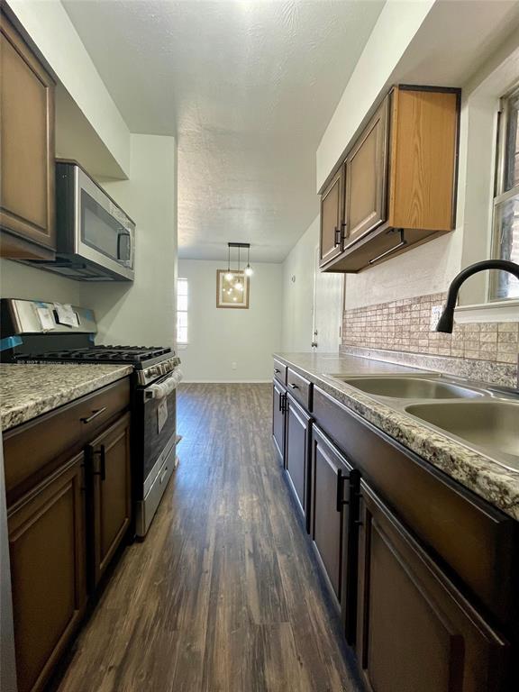 3543 Terrell Street Dallas, TX 75223 - Photo 13 of 26 a kitchen with stainless steel appliances granite countertop wooden cabinets stove top oven and sink