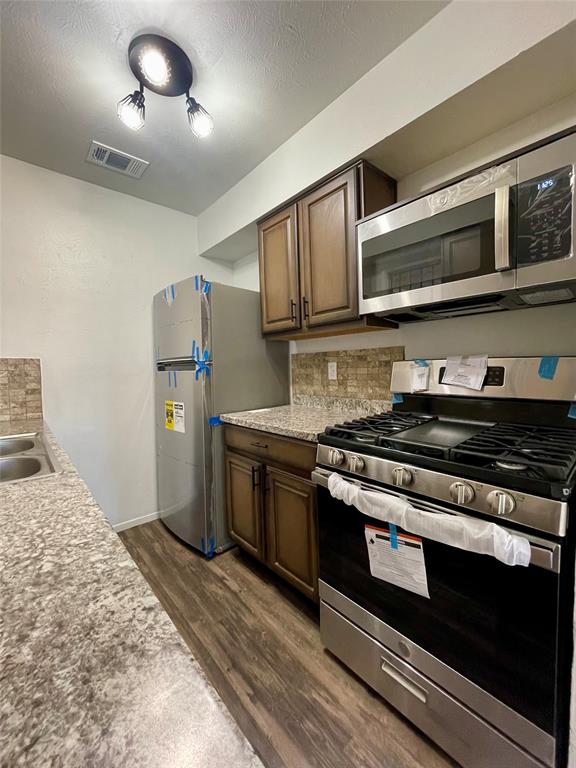 3543 Terrell Street Dallas, TX 75223 - Photo 9 of 26 a kitchen with stainless steel appliances granite countertop a stove and a sink