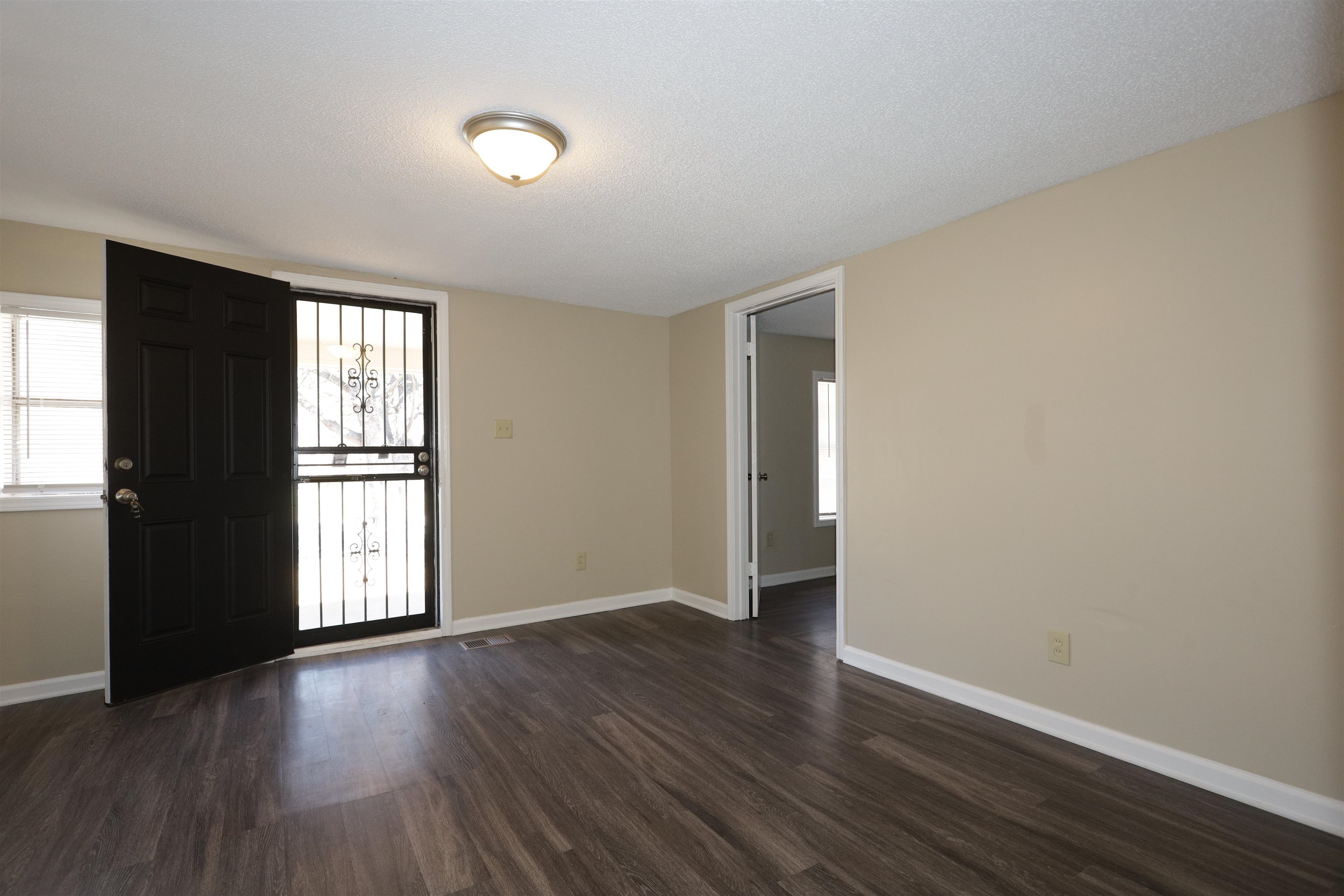 1825 Fields Road Memphis, TN 38109 - Photo 2 of 10 an empty room with wooden floor and windows