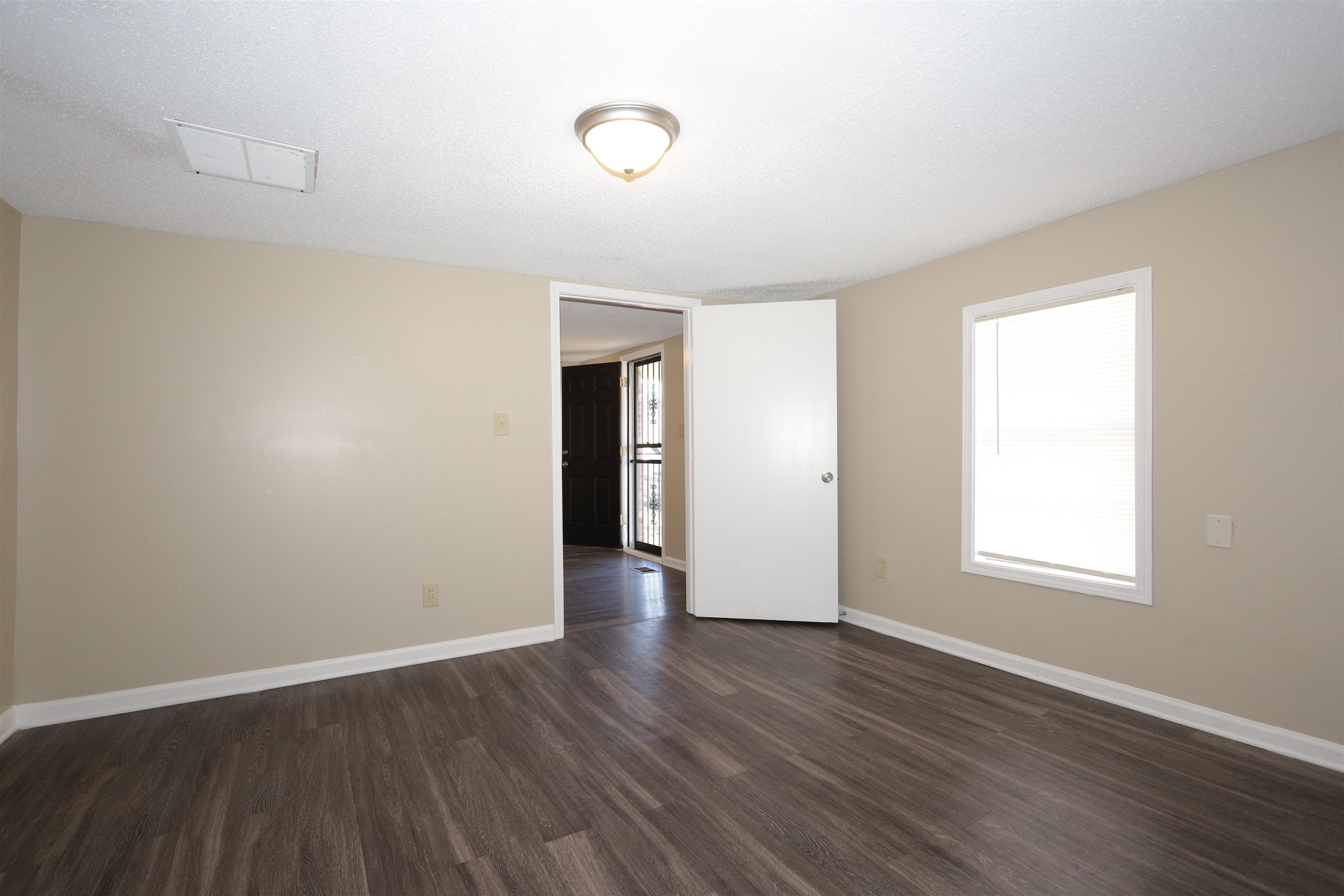 1825 Fields Road Memphis, TN 38109 - Photo 5 of 10 an empty room with wooden floor and windows