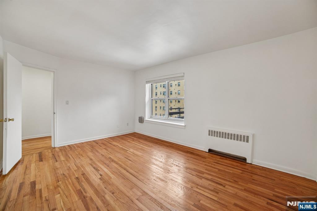 2430 8th Street, Unit 5B Fort Lee, NJ 07024 - Photo 11 of 20 a view of an empty room with wooden floor and a window