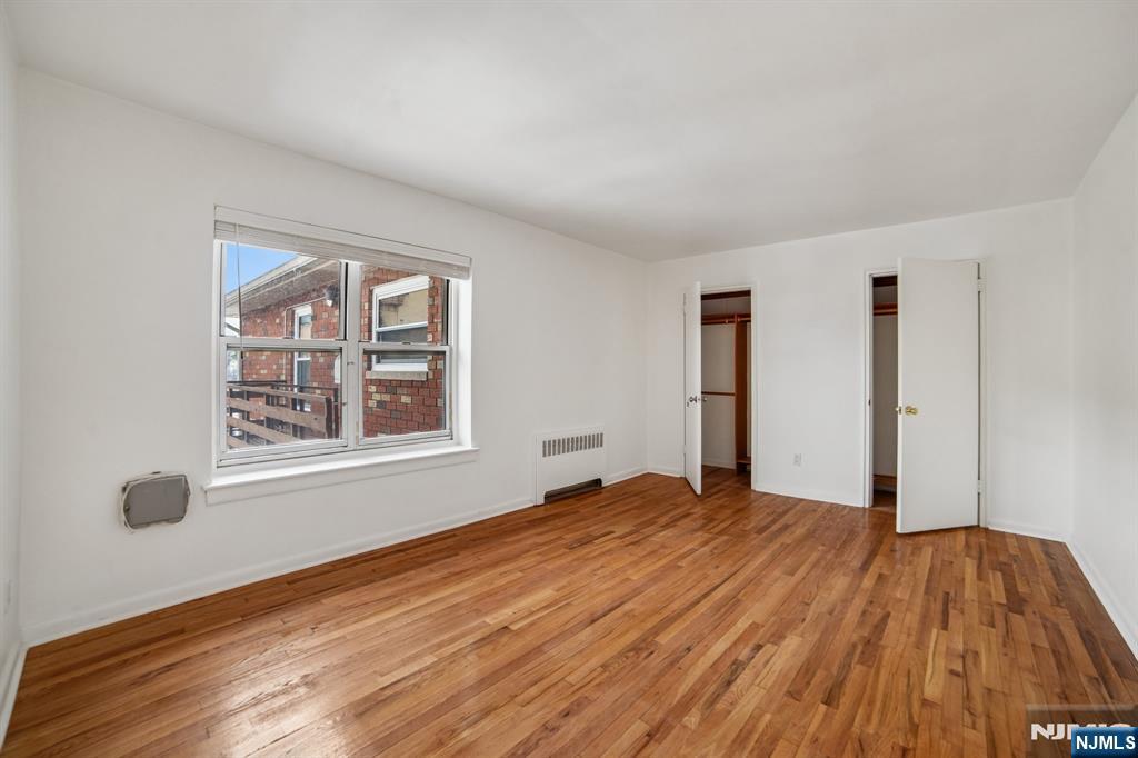 2430 8th Street, Unit 5B Fort Lee, NJ 07024 - Photo 8 of 20 a view of an empty room with wooden floor and a window