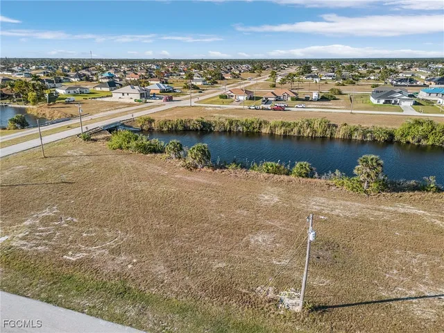an aerial view of ocean and residential houses with outdoor space