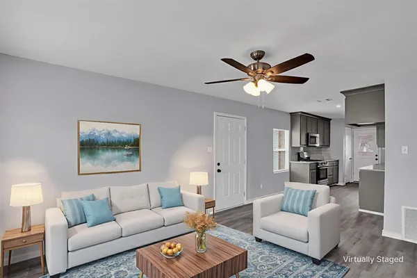 a living room with furniture and a ceiling fan