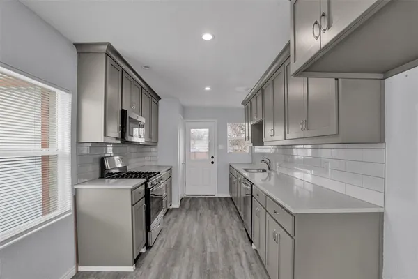 a kitchen with a sink stove and cabinets