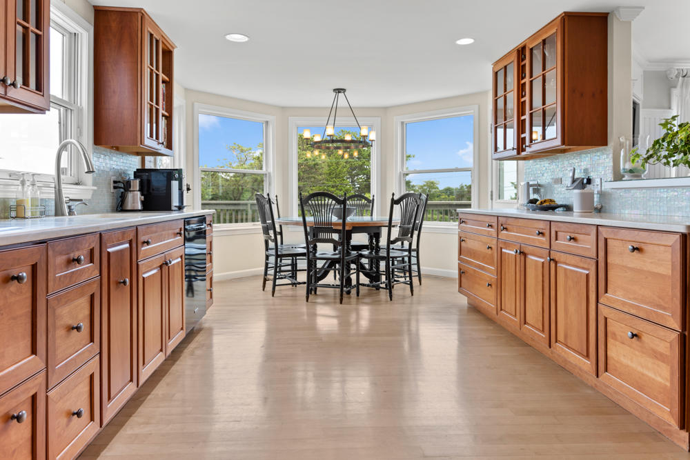 42 Gosnold Road Orleans, MA 02653 - Photo 20 of 42 a kitchen with stainless steel appliances granite countertop a stove top oven a sink dishwasher a dining table and chairs with wooden floor