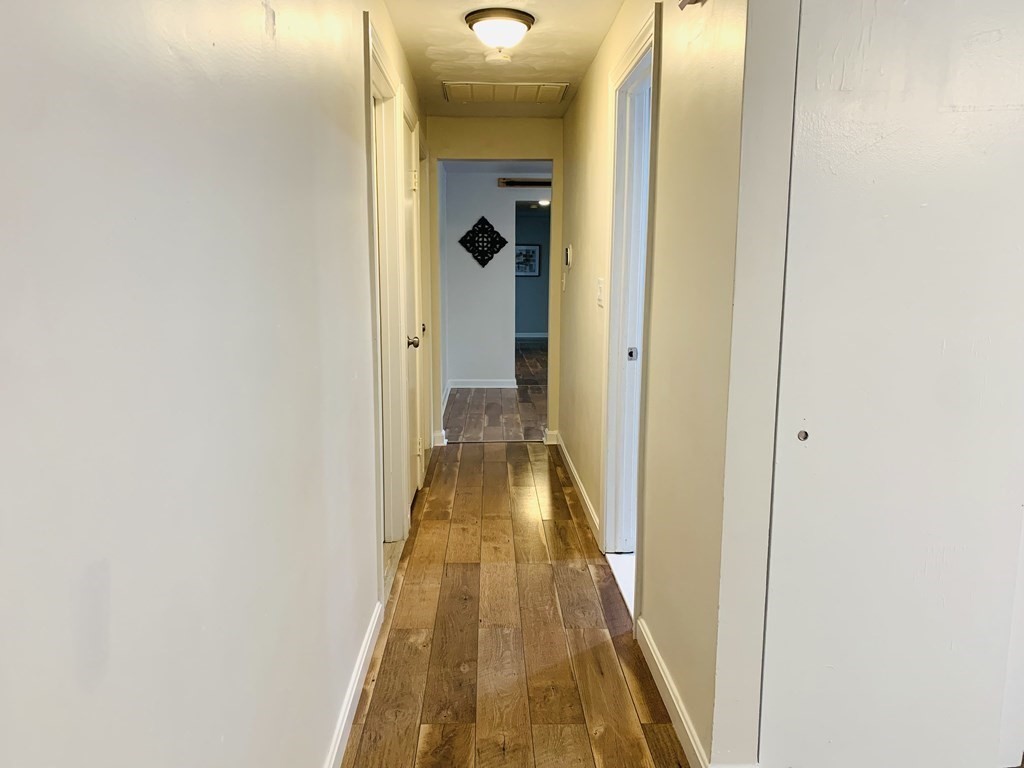 24 Algonquin Road Chelmsford, MA 01824 - Photo 16 of 38 a view of a hallway with wooden floor and a bathroom
