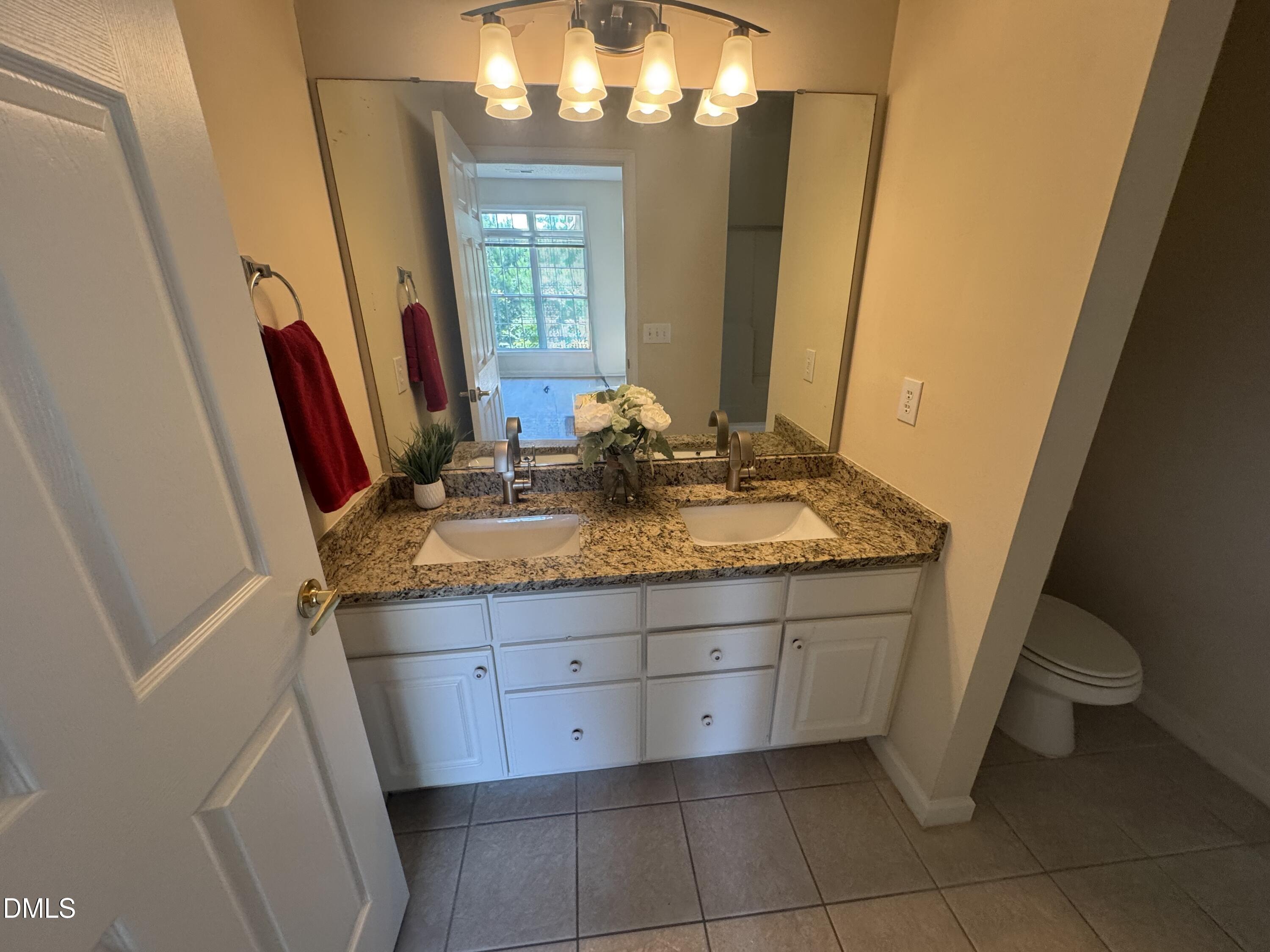 2520 Friedland Place, Unit 202 Raleigh, NC 27617 - Photo 11 of 14 a bathroom with a granite countertop sink and a mirror