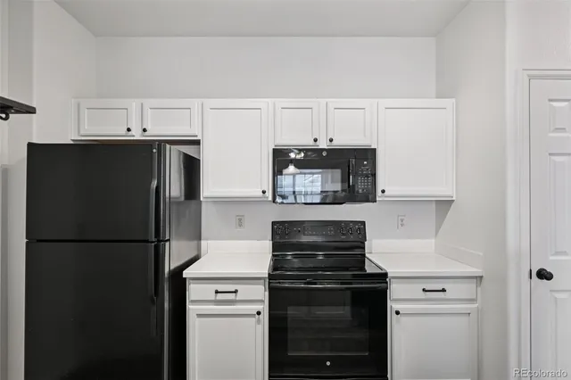 a kitchen with a refrigerator stove and white cabinets