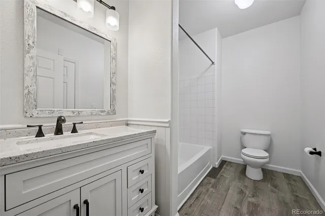 a bathroom with a granite countertop sink toilet and mirror