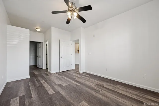 an empty room with closet and a ceiling fan