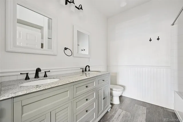 a bathroom with a granite countertop sink a toilet and a mirror