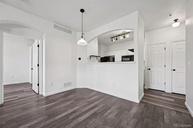 a view of a hallway with wooden floor and chandelier