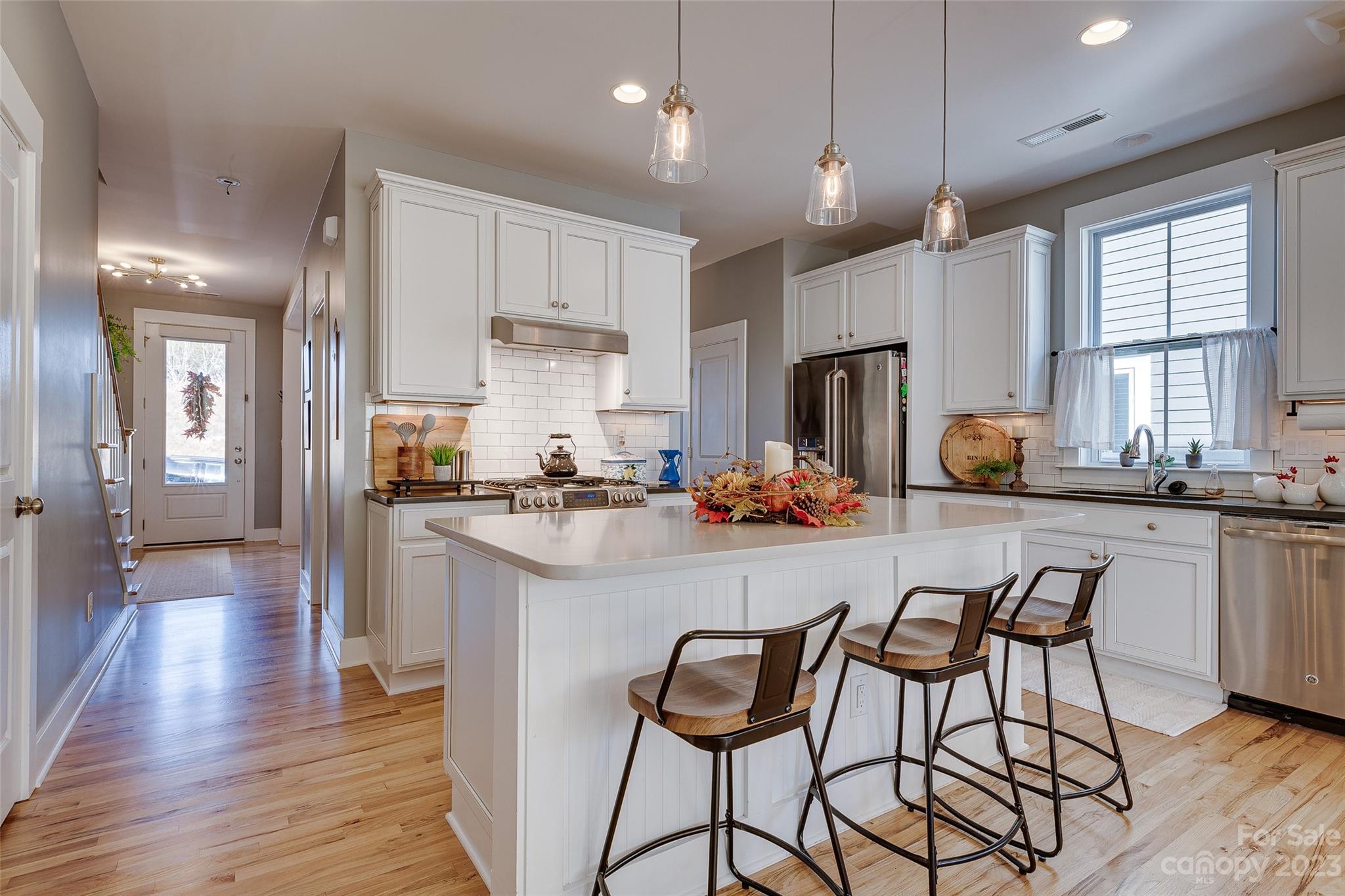 664 Bluff Loop Road Rock Hill, SC 29730 - Photo 7 of 26 a kitchen with stainless steel appliances granite countertop a refrigerator a stove a sink dishwasher and a dining table with wooden floor