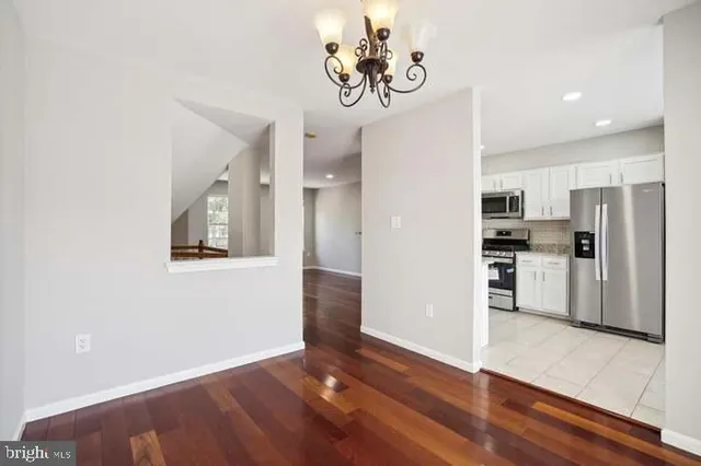 a view of a kitchen with wooden floor and a refrigerator