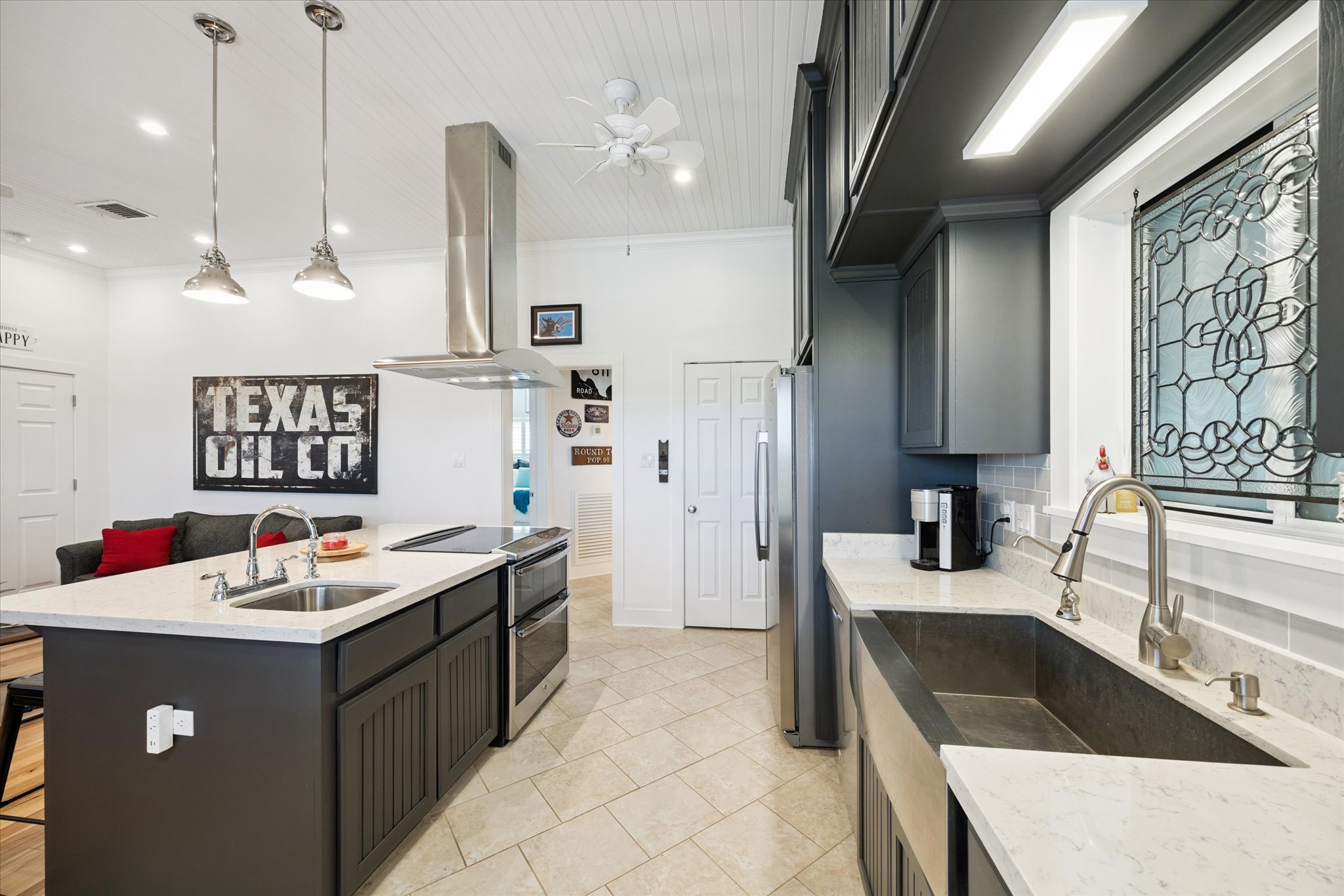 5100 Jaeger Road Burton, TX 77835 - Photo 15 of 34 Kitchen featuring appliances with stainless steel finishes, island range hood, light stone counters, hanging light fixtures, and crown molding