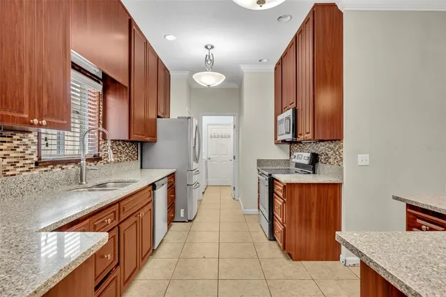 a large kitchen with stainless steel appliances granite countertop a sink counter space and a view of counter top space