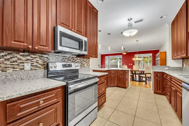 a kitchen with stainless steel appliances granite countertop wooden cabinets a stove and a sink