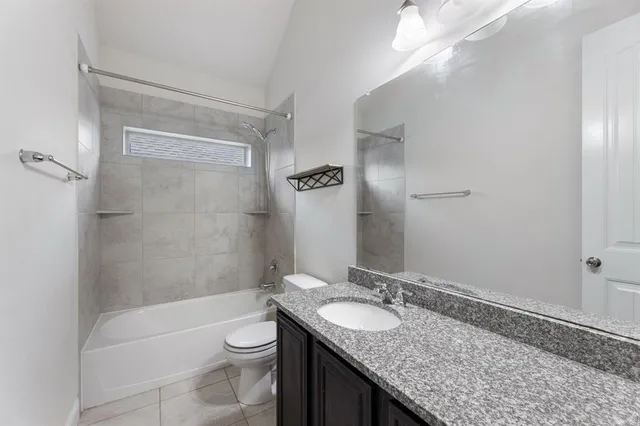 an empty room with a chandelier fan and wooden floor