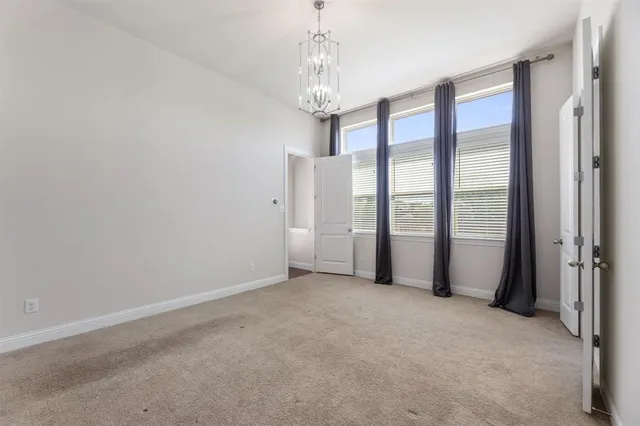 a view of empty room with chandelier and glass door
