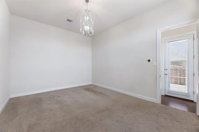 a view of a big room with windows and chandelier