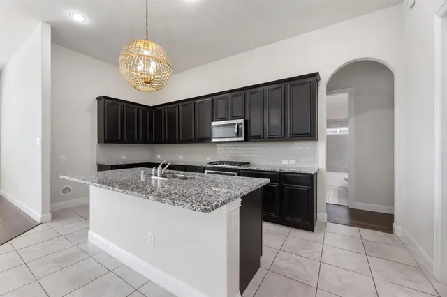 a kitchen with stainless steel appliances granite countertop a sink and a stove