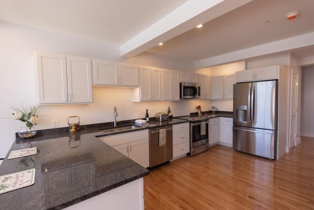 10 Deerfield Avenue, Unit 5 Shelburne, MA 01370 - Photo 11 of 28 a kitchen with granite countertop a refrigerator sink and wooden cabinets