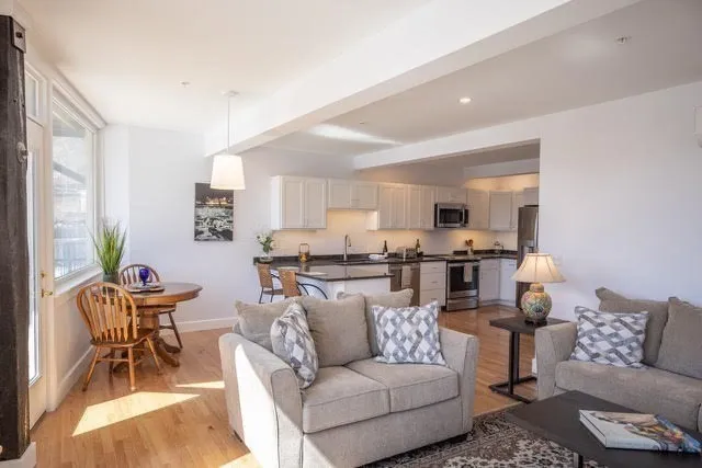 a living room with furniture and view of kitchen