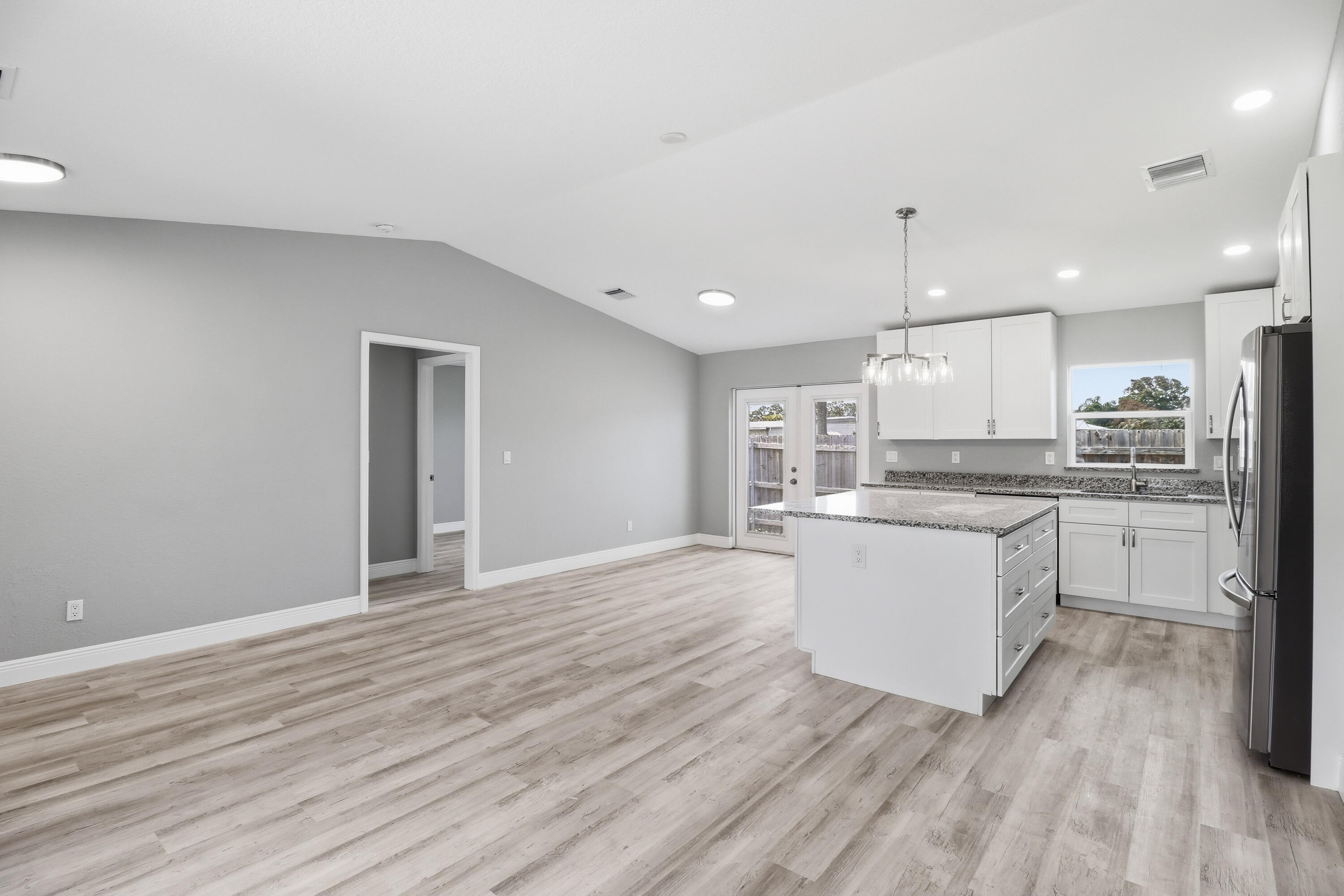 2805 Southeast Carroll Street Stuart, FL 34997 - Photo 2 of 21 a kitchen with a refrigerator and white cabinets
