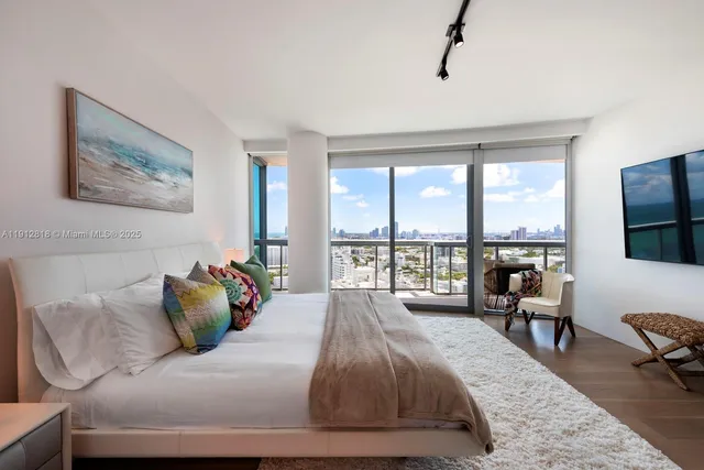 a bedroom with a bed and a large window