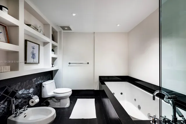 a bathroom with a double vanity sink toilet and mirror