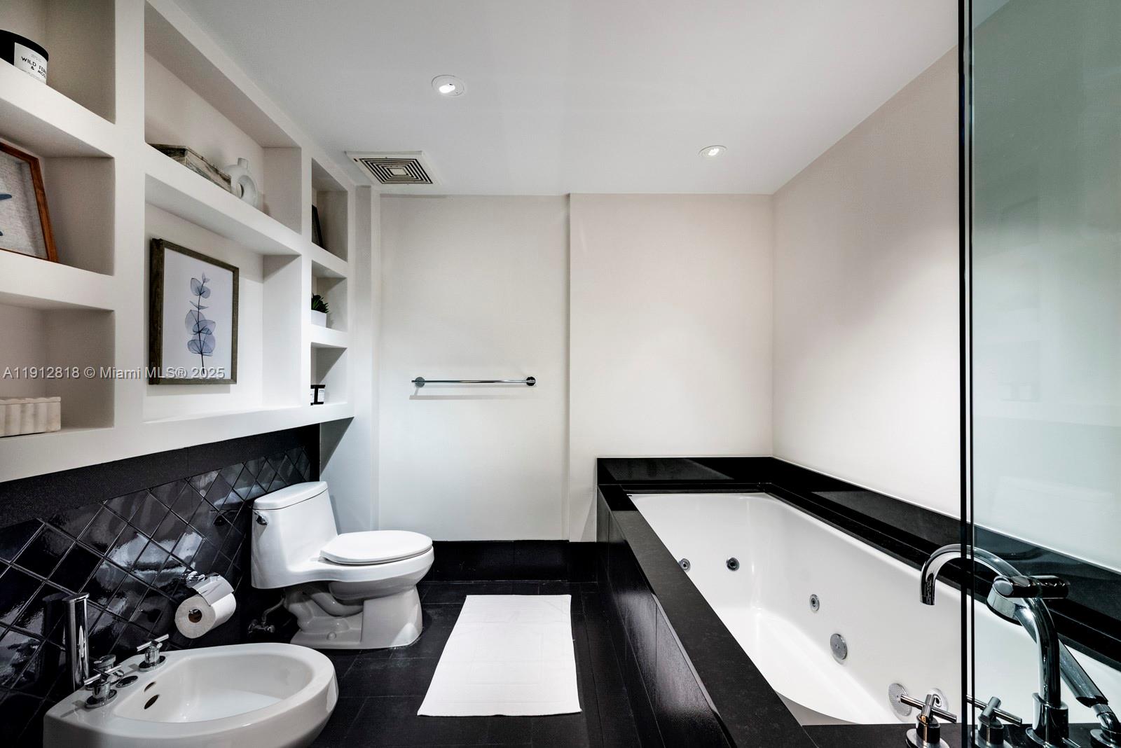 101 20th Street, Unit 3006 Miami Beach, FL 33139 - Photo 13 of 18 a bathroom with a double vanity sink toilet and mirror