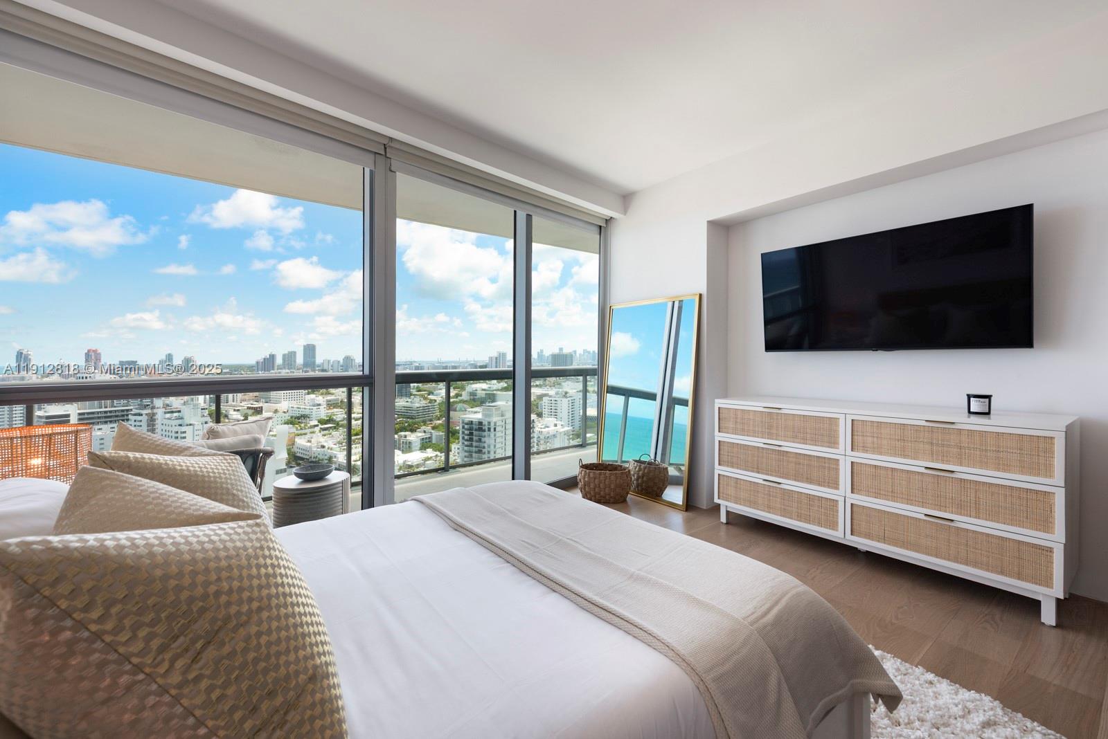 101 20th Street, Unit 3006 Miami Beach, FL 33139 - Photo 17 of 18 a bedroom with a bed and a flat screen tv