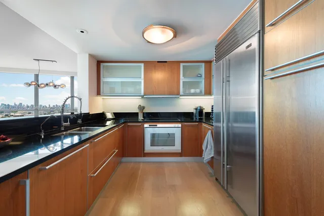 a kitchen with stainless steel appliances granite countertop a refrigerator a stove and a sink
