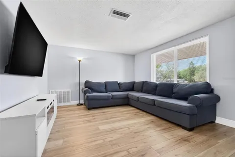 a living room with furniture flat screen tv and a large window